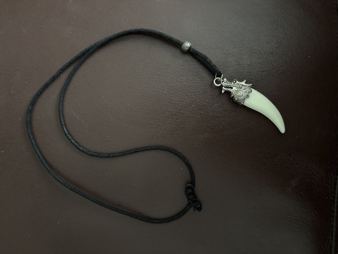Black cord wolf tooth pendant with an silver wolf-head cap. For one of my friends bought at Farplace Animal Rescue Shop for £1.00