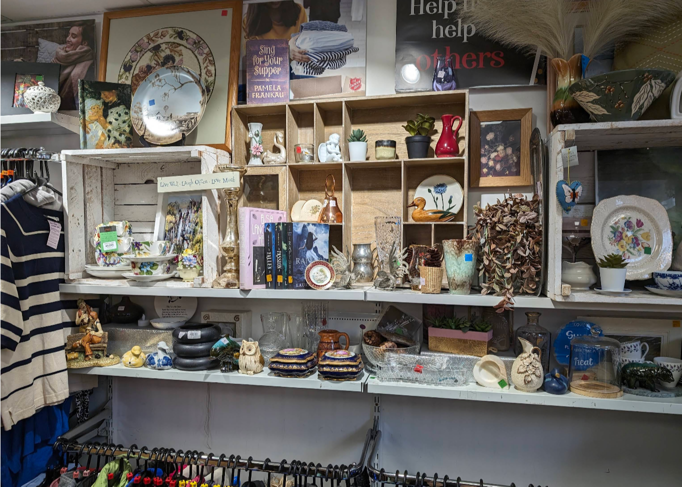 Interior of the Salvation Army charity shop in St Andrews, Scotland, showing shelves packed with colourful bric-a-brac and assorted clothing