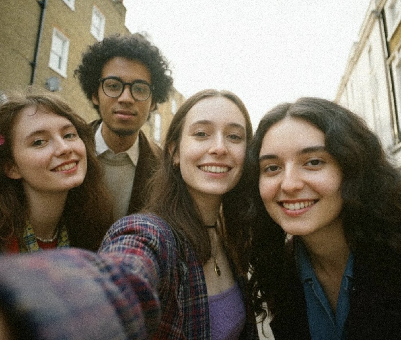 A group of friends in vintage retro fashion posing and taking a selfie in the streets of Peckham