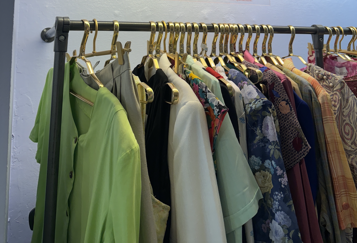 Rail of clothes on hangers in a charity shop