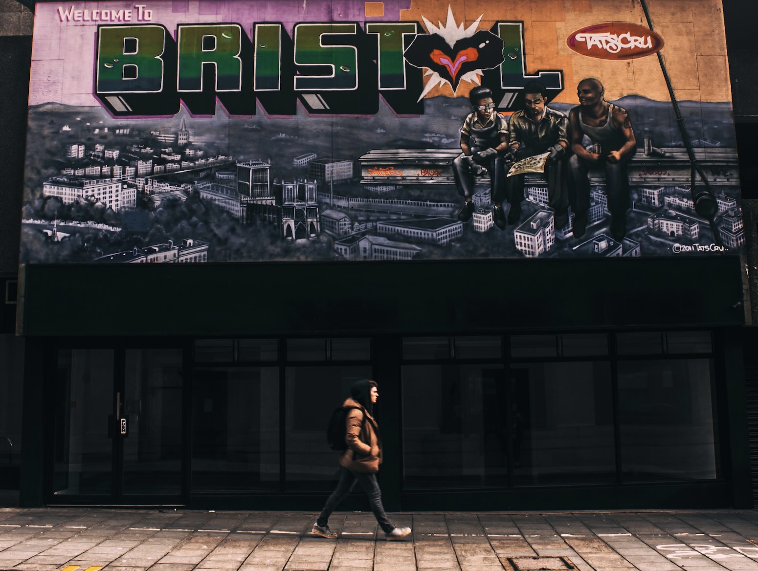 A man walking under the welcome sign of Bristol