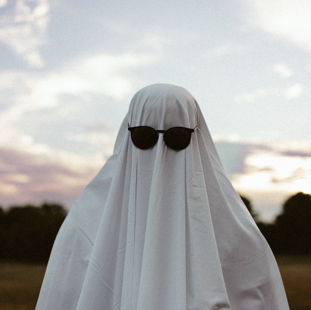 A person standing outside who is dressed as a ghost for halloween