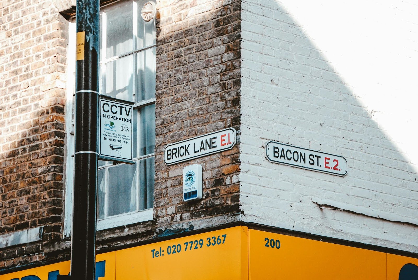 An image of two street signs at the corner of Brick Lane