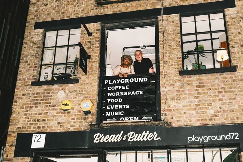 Two of the owners looking out of a top floor window at Bread & Butter Collective