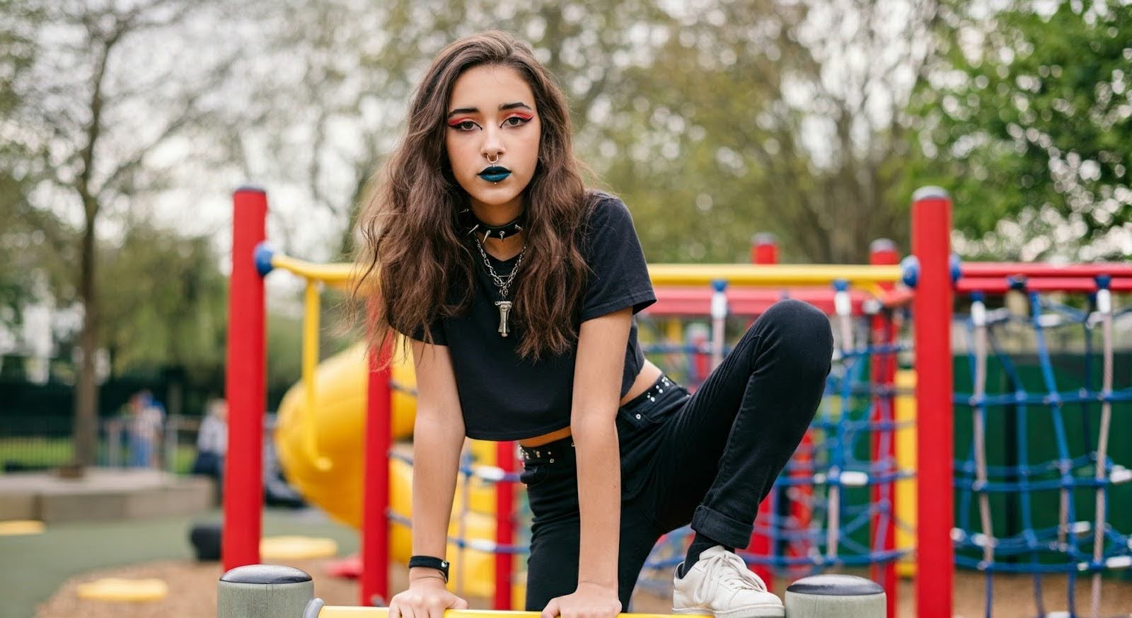A GenZ girl posing in a London play park in Y2K baby tee fashion.