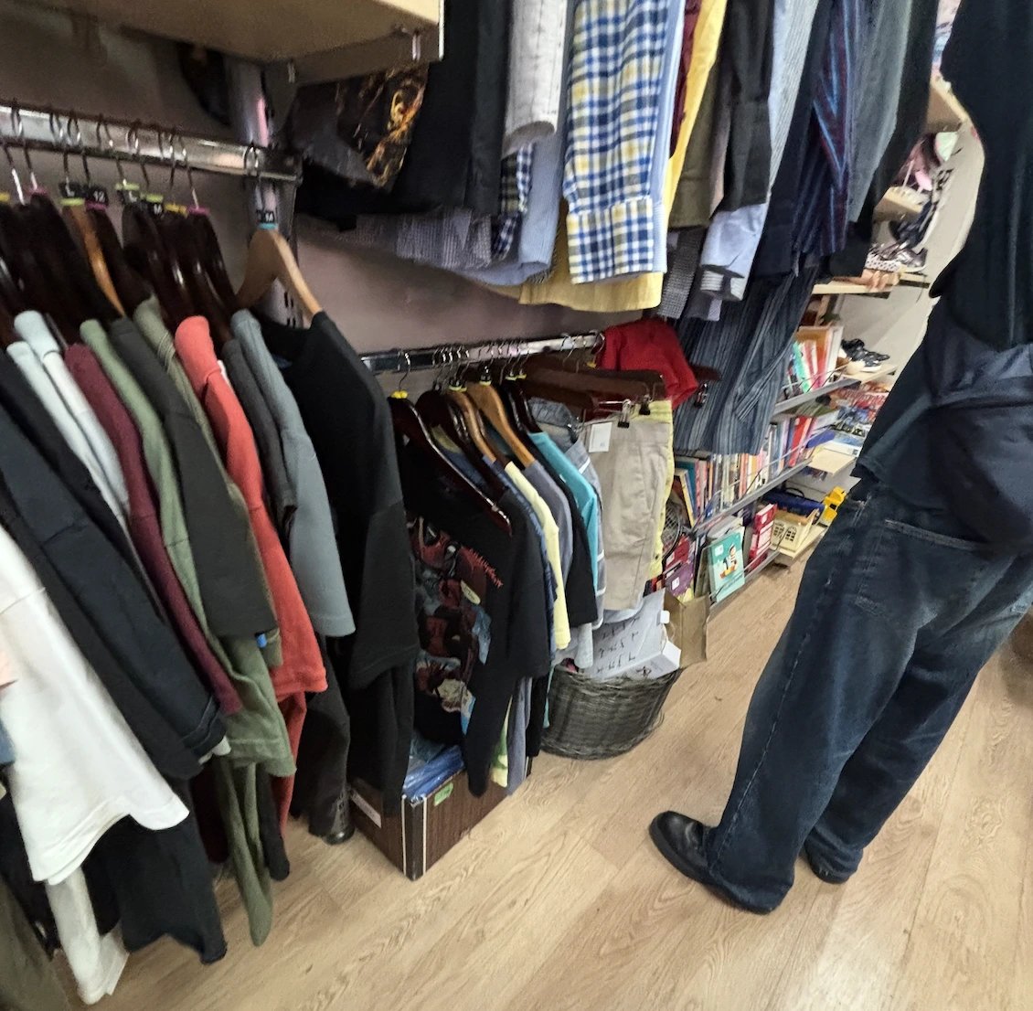 A charity shopper going through the clothing rail of a charity shop in London