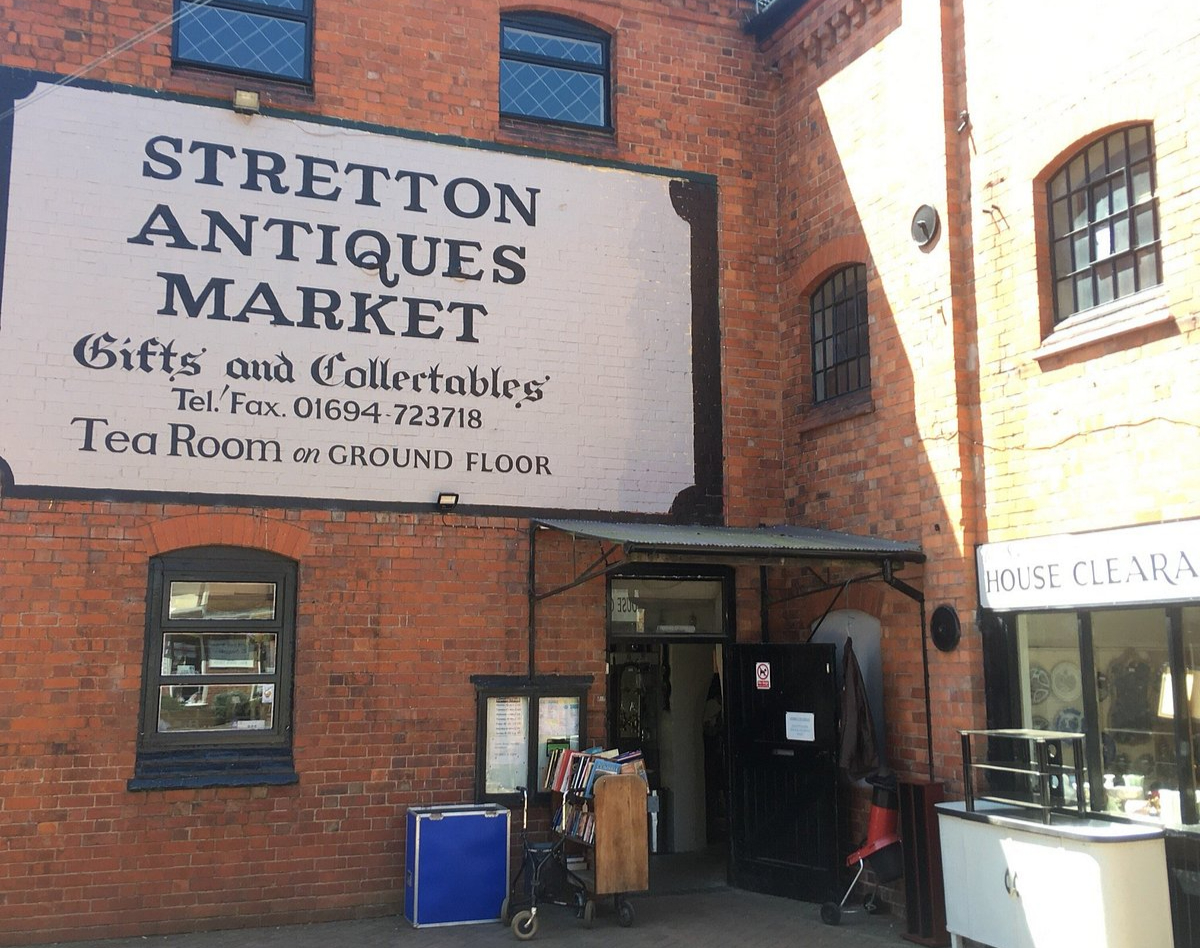 Exterior of Stretton Antiques Market in Church Stretton, Shropshire, showing the historic brick building and painted sign