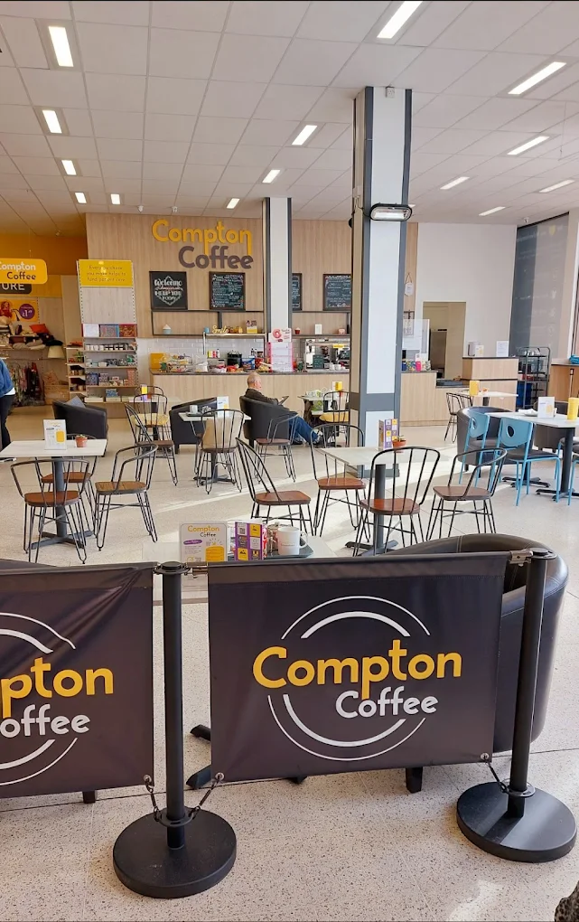 Compton Coffee cafe interior with seating area, tables and chairs, and service counter