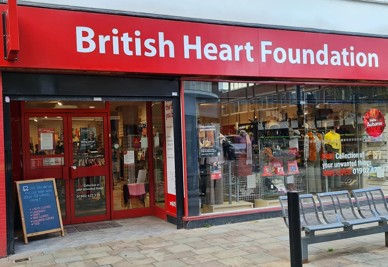 British Heart Foundation charity shop exterior with red signage and clothing window display