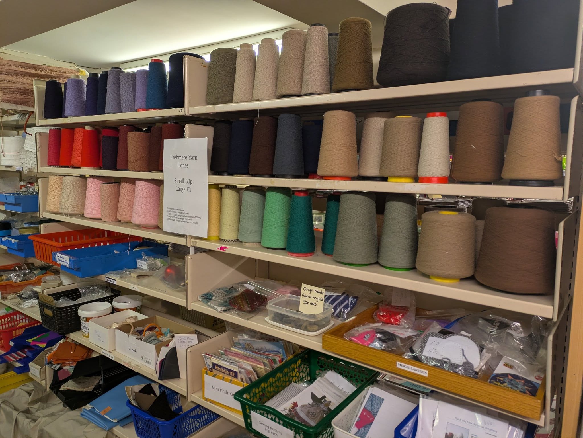 Cashmere yarn and thread cones on shelves at Scrappies craft and reuse shop in Church Stretton