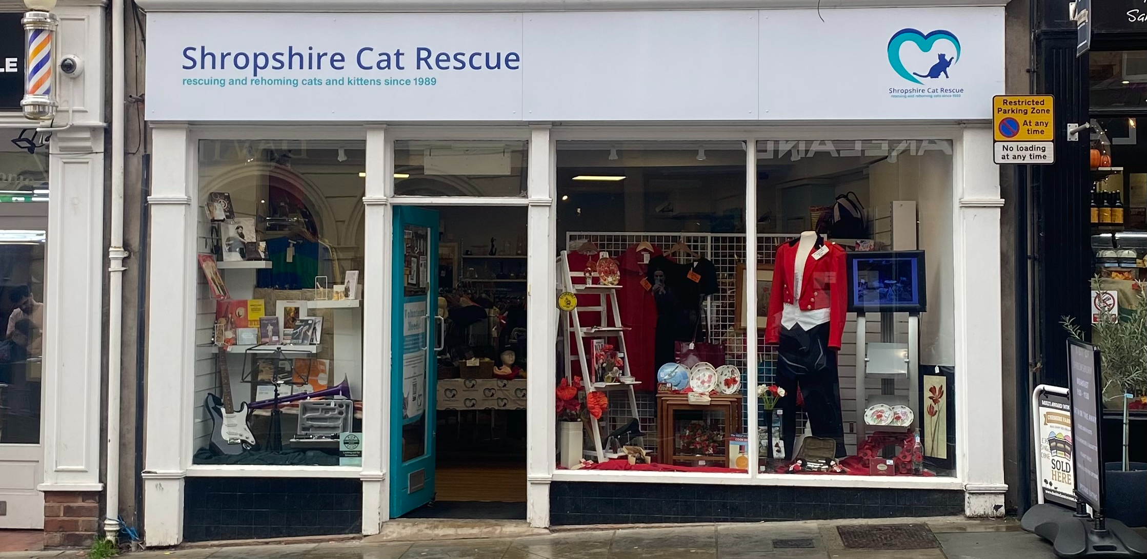 Exterior of the Shropshire Cat Rescue charity shop in Shrewsbury, showcasing its window displays of second-hand clothing, books, and homeware.