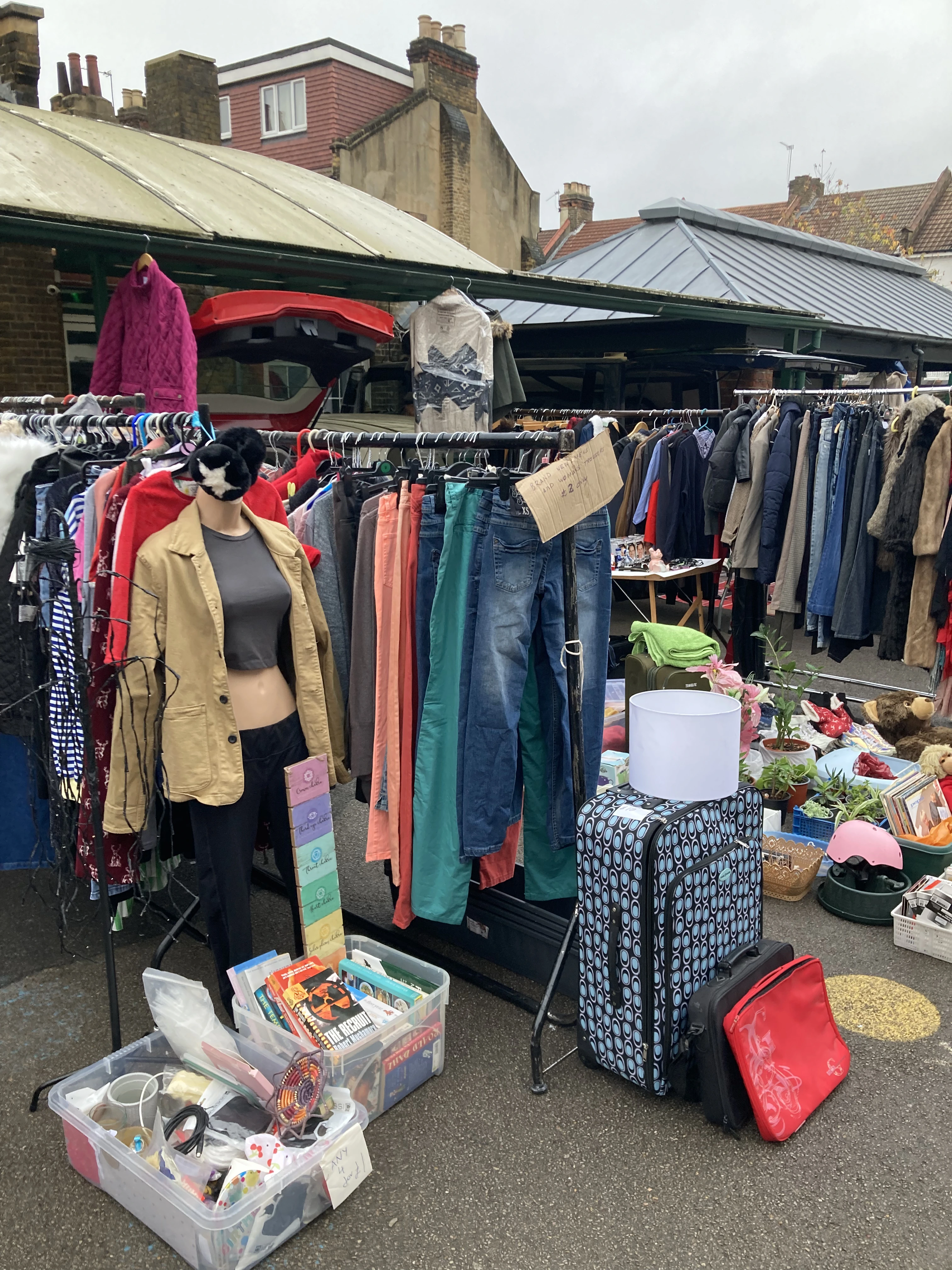 Second-hand market stall with rails of pre-loved clothing, jeans and vintage finds